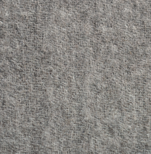 Close-up of the ELEMENTA Piedra throw blanket in mid gray baby alpaca, showing its fine, soft weave