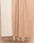 Ivory and beige reversible baby alpaca throw styled on neutral linen chair in bright room