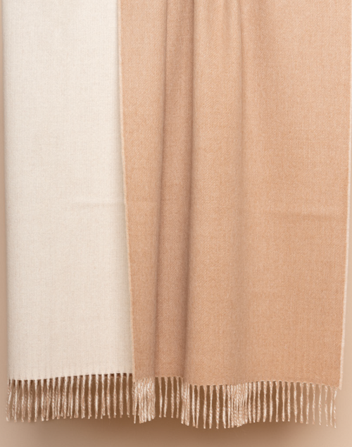 Ivory and beige reversible baby alpaca throw styled on neutral linen chair in bright room