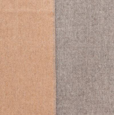 Beige and gray reversible baby alpaca throw blanket draped over sofa in modern living room