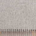 Mid gray baby alpaca throw blanket draped over armchair in minimalist living space