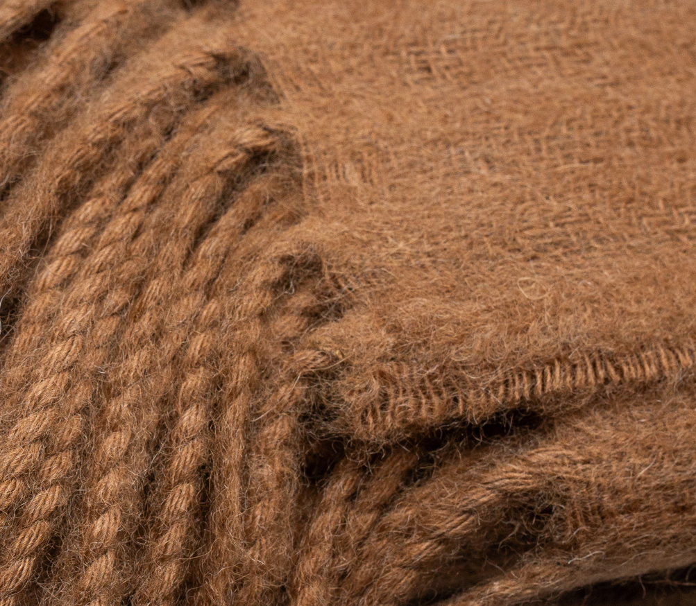 Close-up of the twisted fringe on the ELEMENTA Tero throw blanket in camel baby alpaca